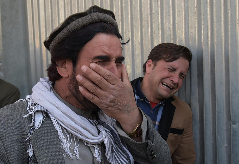 <p>Two Afghan men weep for their relatives in front of the main gate of a military hospital in Kabul on March 8, 2017, after a deadly six-hour attack claimed by the Islamic State group.<br> More than 30 people were killed and around 50 wounded in an insurgent attack on Afghanistan’s largest military hospital in Kabul on March 8, the defence ministry said. (Photo: Shah Marai/ AFP/Getty Images) </p>