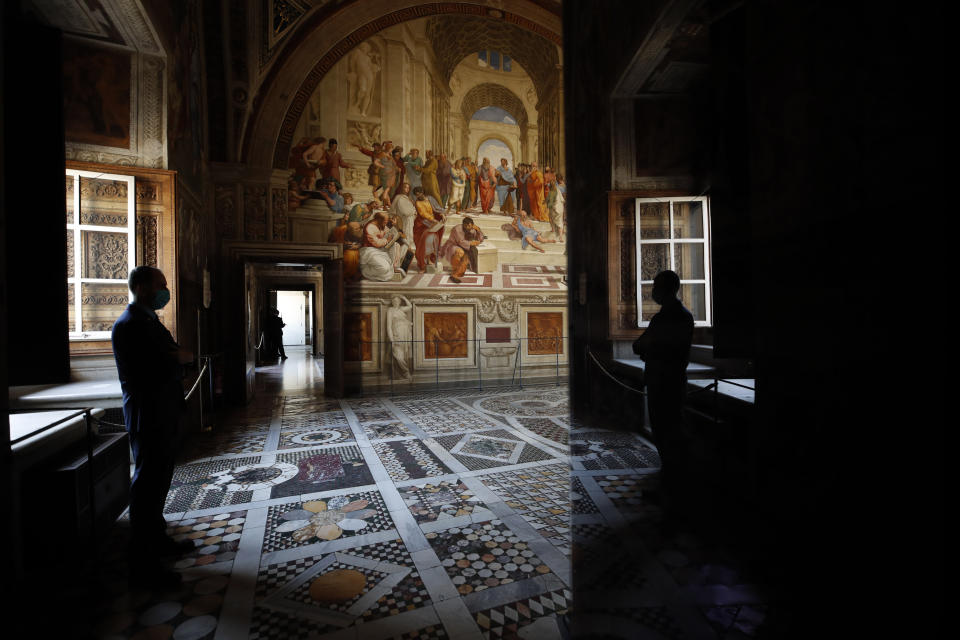 An employee wearing a mask to prevent the spread of COVID-19 stands inside a Raphael Room of the Vatican Museums on their reopening, in Rome, Monday, May 3, 2021. The Vatican Museums reopened Monday to visitors after a shutdown following COVID-19 containment measures. (AP Photo/Alessandra Tarantino)