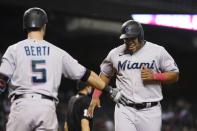 Miami Marlins' Jesus Aguilar, right, smiles as he celebrates with Jon Berti after scoring against the Arizona Diamondbacks during the seventh inning of a baseball game Thursday, May 13, 2021, in Phoenix. (AP Photo/Ross D. Franklin)