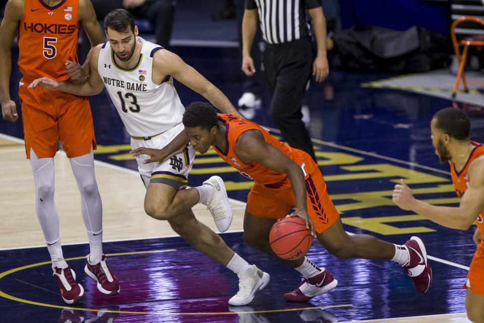 Virginia Tech's Nahiem Alleyne starts to bring the ball up, next to Notre Dame's Nikola Djogo (13) during the first half of an NCAA college basketball game Wednesday, Jan. 27, 2021, in South Bend, Ind. (AP Photo/Robert Franklin)