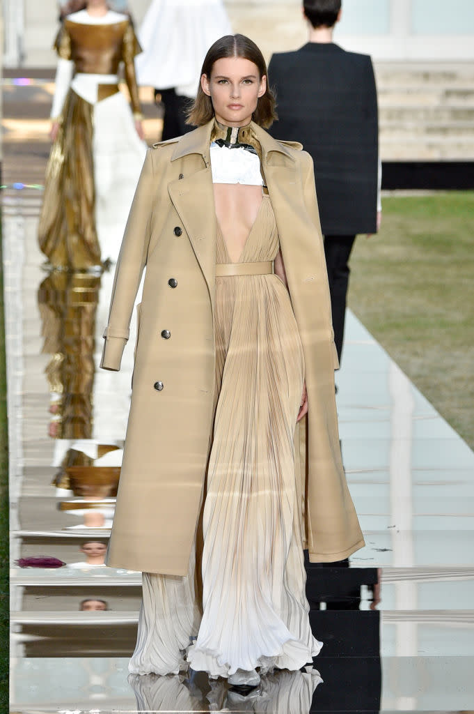 <p>Model wears a light beige ombré pleated gown with matching trench coat and metal choker from the Givenchy fall 2018 couture collection. (Photo: Getty Images) </p>