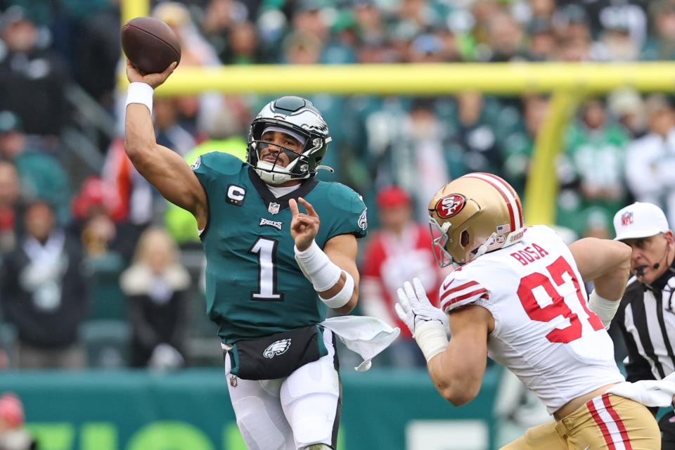 Philadelphia Eagles quarterback Jalen Hurts (1) throws a pass under pressure from San Francisco 49ers defensive end Nick Bosa (97) during the first quarter in the NFC Championship game at Lincoln Financial Field.