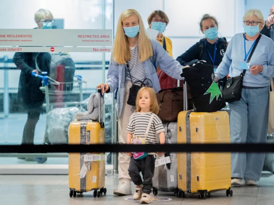 Ukrainians fleeing the war arrive in Montreal on May 29 aboard one of three government-sponsored charter flights from Poland. As of May 30, nearly 40,000 Ukrainians had arrived in Canada this year, according to government statistics. (Graham Hughes/The Canadian Press - image credit)