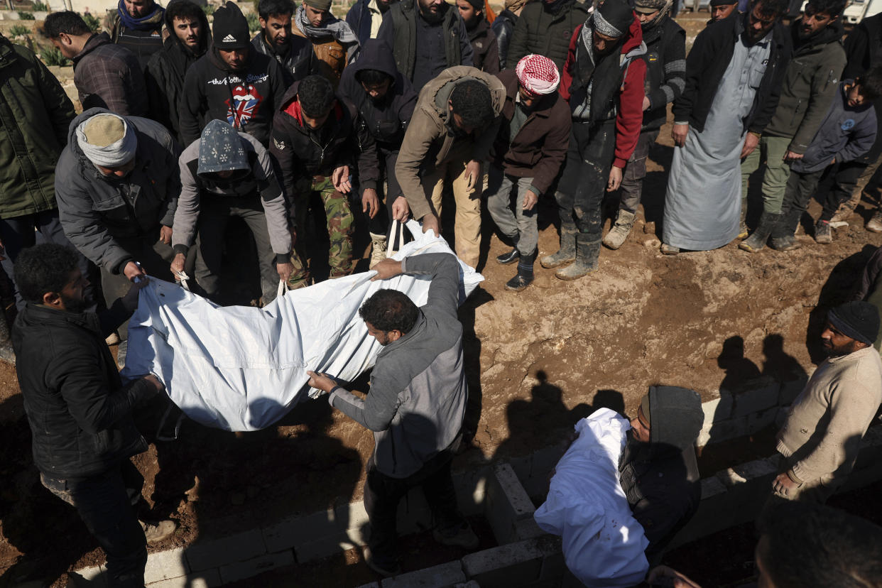 Mourners bury family members who died in a devastating earthquake that rocked Syria and Turkey at a cemetery in the town of Jinderis, Aleppo province, Syria, Tuesday, Feb. 7, 2023. A newborn girl was found buried under debris with her umbilical cord still connected to her mother, Afraa Abu Hadiya, who was found dead, according to relatives and a doctor. The baby was the only member of her family to survive from the building collapse Monday in Jinderis, next to the Turkish border, Ramadan Sleiman, a relative, told The Associated Press. (AP Photo/Ghaith Alsayed)