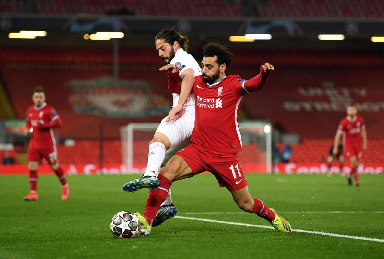 LIVERPOOL, ENGLAND - APRIL 14:  Mohamed Salah of Liverpool is challenged by Isco of Real Madrid during the UEFA Champions League Quarter Final Second Leg match between Liverpool FC and Real Madrid at Anfield on April 14, 2021 in Liverpool, England. Sporting stadiums around the UK remain under strict restrictions due to the Coronavirus Pandemic as Government social distancing laws prohibit fans inside venues resulting in games being played behind closed doors.  (Photo by Shaun Botterill/Getty Images)