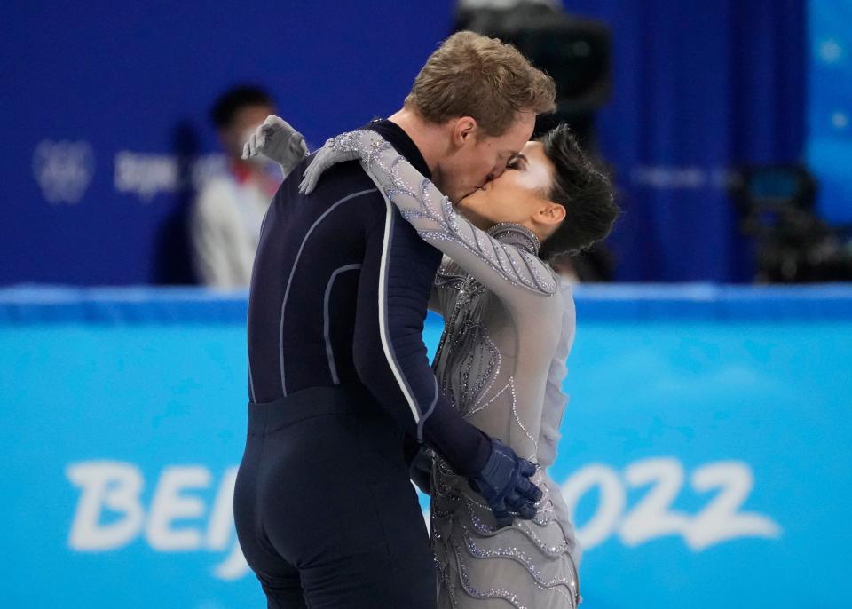Madison Chock and Evan Bates kiss after performing in the free dance portion of the figure skating mixed team final during the Beijing Olympics.