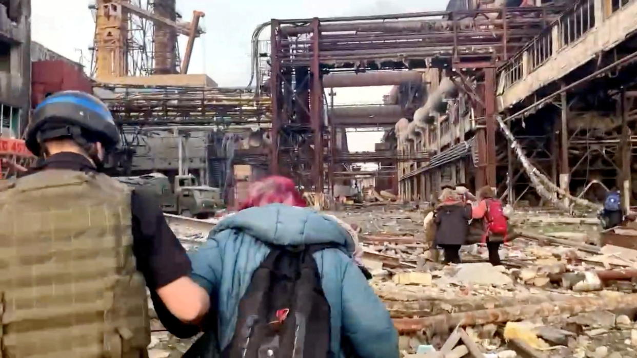 Ukrainian forces walk with civilians during an evacuation of the Azovstal steel plant.
