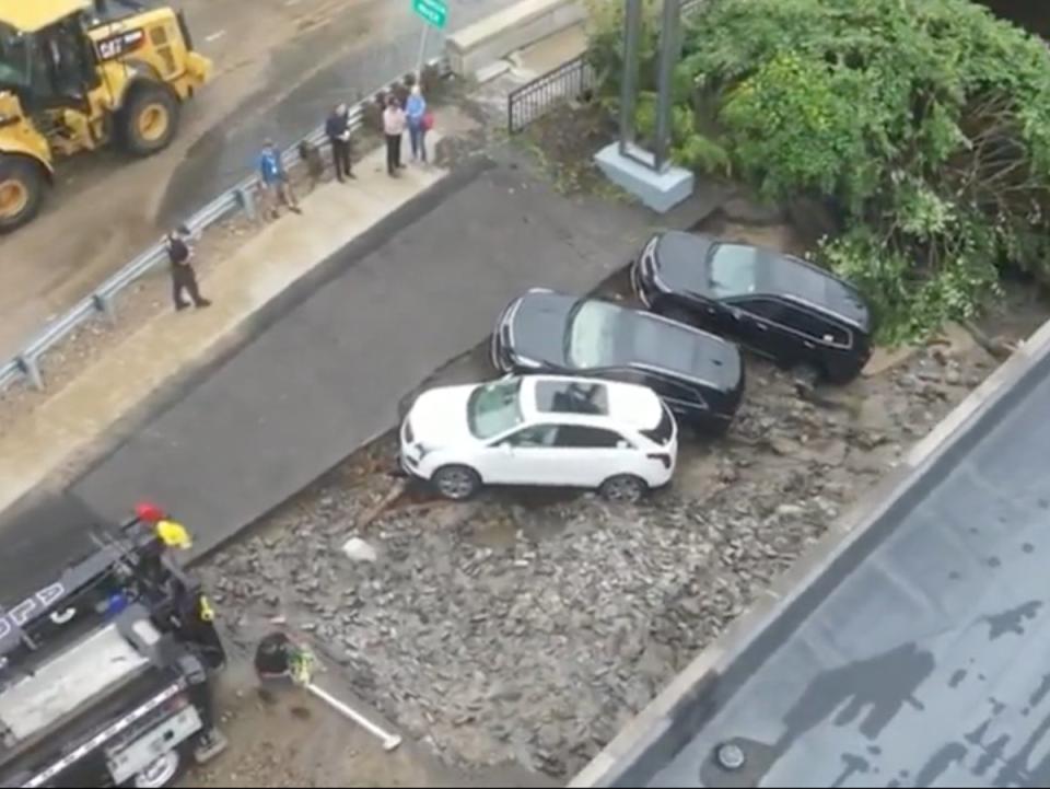 A trio of cars caught on the edge of a sinkhole that opened up in Leominster, Massachusetts after heavy rains (screengrab/WCVB)