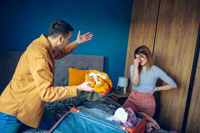 <p>Getty</p> stock image of a couple arguing while packing a suitcase