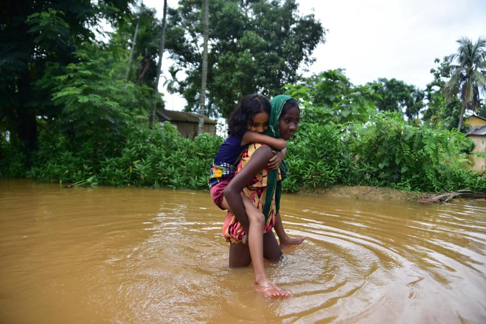 NAGAON,INDIA-JULY 22,2020 :Girls wade through flood water at a flood-affected village in Nagaon district of Assam,India - PHOTOGRAPH BY Anuwar Ali Hazarika / Barcroft Studios / Future Publishing (Photo credit should read Anuwar Ali Hazarika/Barcroft Media via Getty Images)