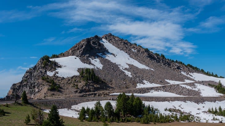 <span class="article__caption">Snow flecks the trail up to the fire lookout (just visible at the top of the ridge) at Watchman Overlook in Crater Lake National Park.</span> (Photo: Kelly VanDellen/Getty)