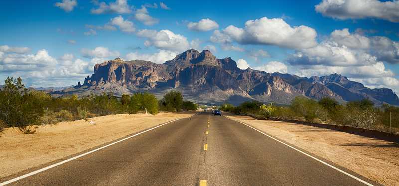 The open road with blue sky and mountains.