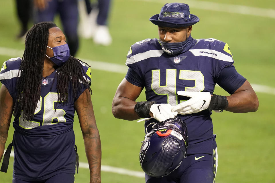 Seattle Seahawks defensive end Carlos Dunlap (43) leave the field with cornerback Shaquill Griffin (26) after an NFL football game against the San Francisco 49ers, Sunday, Jan. 3, 2021, in Glendale, Ariz. The Seahawks won 26-23. (AP Photo/Ross D. Franklin)