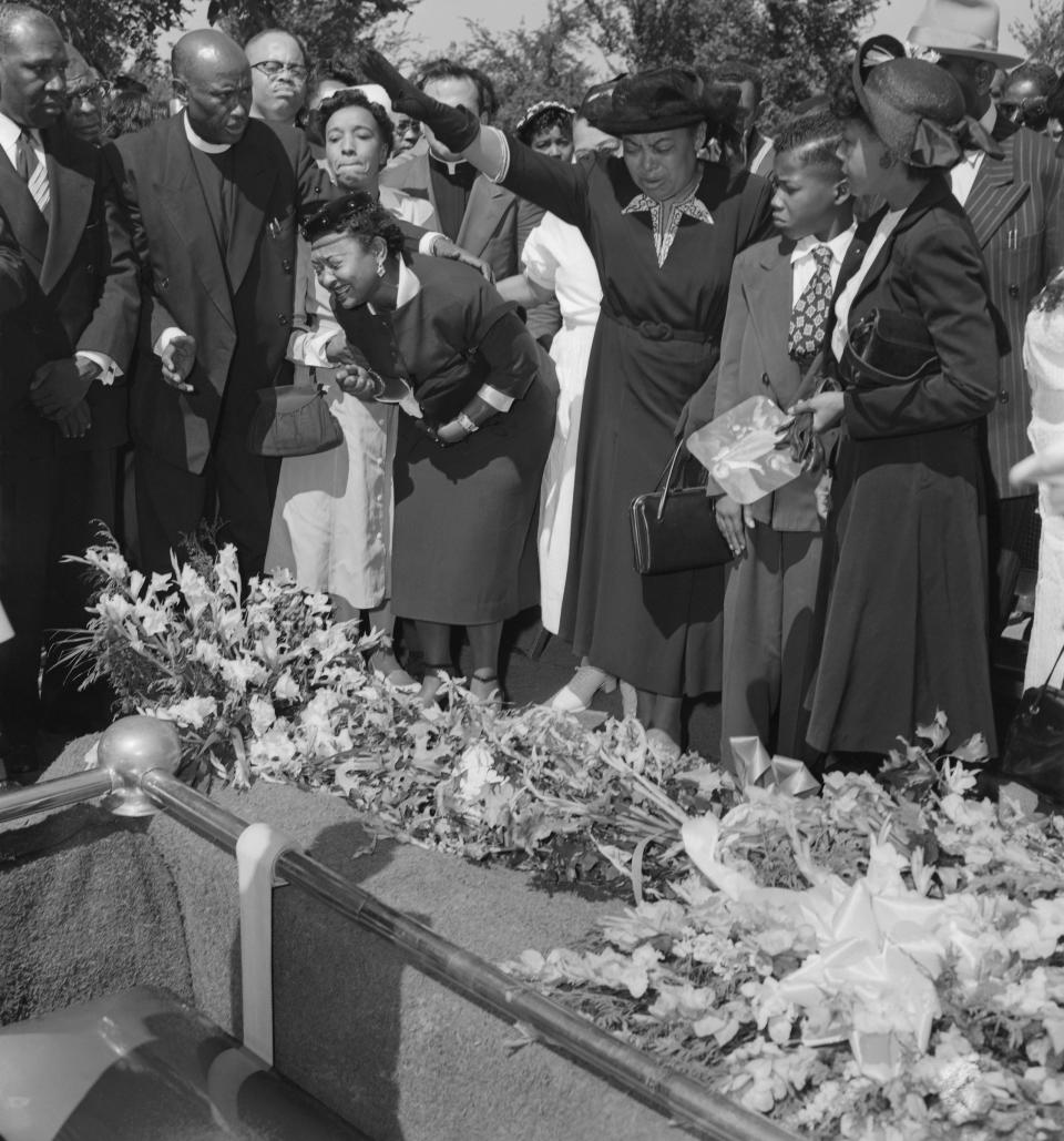 Friends restrain Emmett Till's grief-stricken mother (left) as her son's body is lowered into the grave. | Bettmann Archive