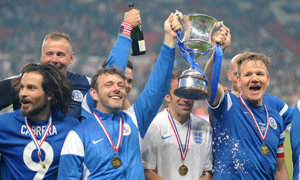 Rest of the World's Michael Sheen and Gordon Ramsay lift the trophy after winning the Soccer aid charity match against England, at Old Trafford, Manchester.