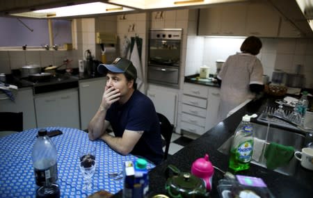 Guillermo Galia waits for his employee to prepare lunch, at his home, in Buenos Aires