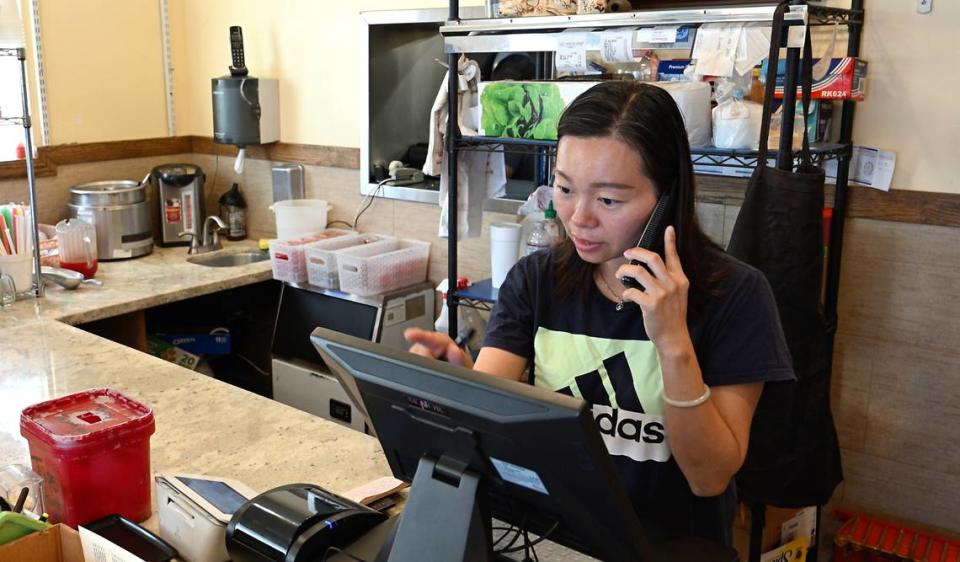 La propietaria del restaurante Lucky House, Winnie Huang, toma nota de un pedido de comida en Riverbank, California, el jueves 27 de junio de 2024.