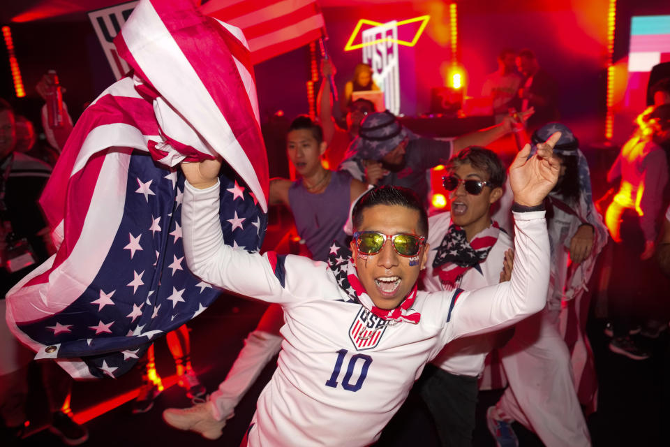 People dance during an official U.S. Soccer fan party at the Budweiser World Club ahead of a FIFA World Cup group B soccer match between the United States and Wales, in Doha, Sunday, Nov. 20, 2022. (AP Photo/Ashley Landis)