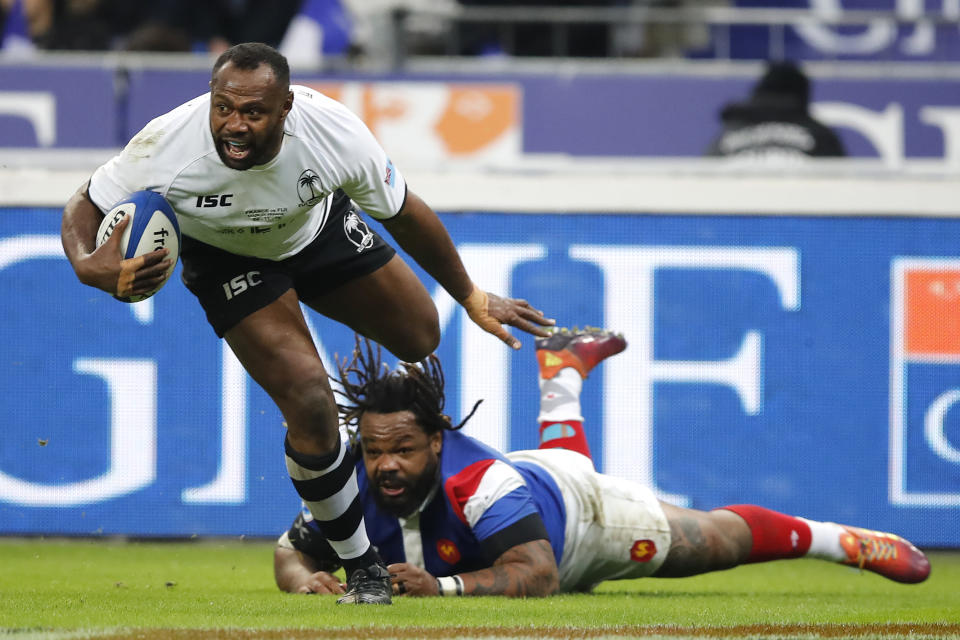 FILE - In this Nov. 24, 2018, file photo, Fiji's Vereniki Goneva evades the tackle of France's Mathieu Bastareaud as he scores a try that was disallowed on video review during the rugby international between France and Fiji at Stade de France in Paris. The powerful Fiji wing and center who will be playing at his third World Cup, Goneva became his nation's leading test try-scorer this season and remains one of the world's most sought-after players at 35. (AP Photo/Christophe Ena, File)