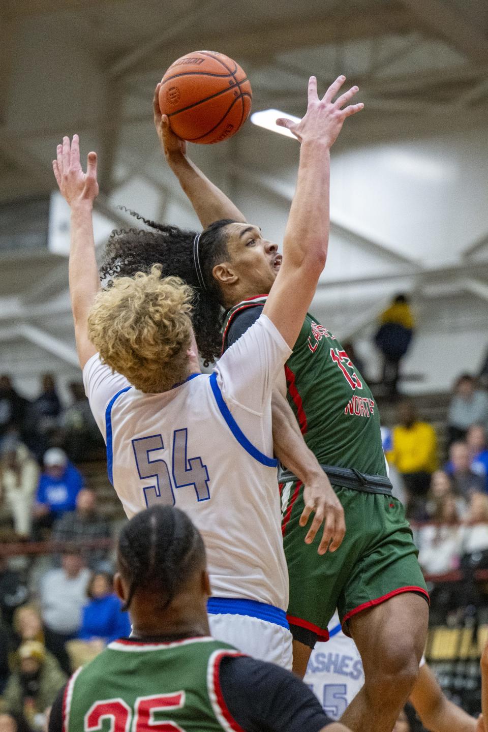 Lawrence North High School senior Kobi Bowles (13) flies toward the goal to dunk while being defended by Franklin Central High School junior Elijah Thompson (54) during the second half of a Boysâ€™ Marion County Basketball Tournament championship game, Saturday, Jan. 13, 2024, at Southport High School. Lawrence North won, 78-53.