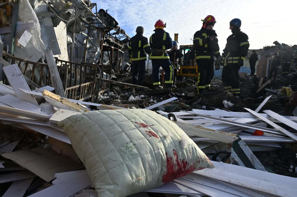 Ukrainian rescuers work on the site following a Russian missile strike on a local market in Shevchenkove village, Kharkiv region, on Jan. 9, 2023.