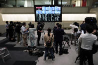 Journalists film an electronic stock board showing reopening of Japan's Nikkei 225 index at Tokyo Stock Exchange in Tokyo Friday, Oct. 2, 2020. Tokyo's market resumed trading Friday after a full-day outage due to a malfunction in its computer systems. (AP Photo/Eugene Hoshiko)