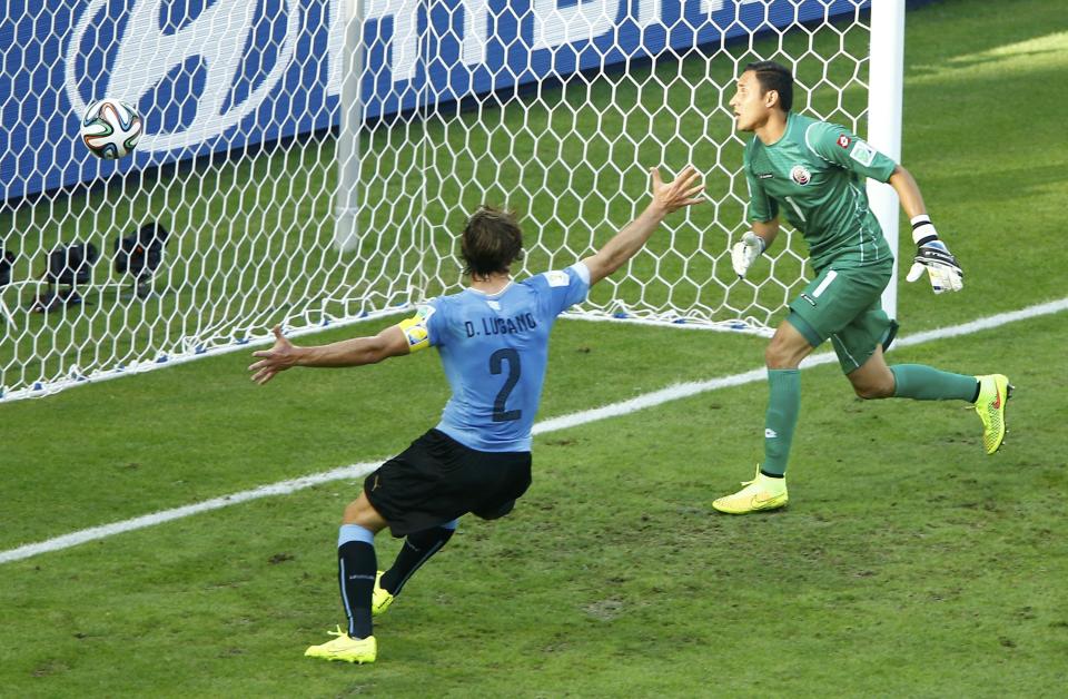 Uruguay's Diego Lugano (L) celebrates teammate Diego Godin's (not pictured) goal, which was later disallowed as after Godin was ruled offside, during their 2014 World Cup Group D soccer match against Costa Rica at the Castelao arena in Fortaleza, June 14, 2014. Also pictured is Costa Rica's Keilor Navas. (Mike Blake/Reuters)