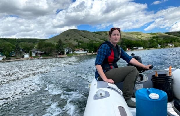 Deirdre Bateson, research manager with Peter Leavitt's lab at the University of Regina, takes a team out on a boat to sample the water at Pasqua Lake in Saskatchewan, an hour northeast of Regina. It was among 383 lakes whose oxygen levels were tracked by researchers for decades and found to be declining. (Bonnie Allen/CBC - image credit)