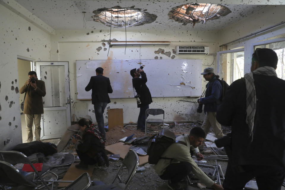 Journalists photograph inside Kabul University after a deadly attack in Kabul, Afghanistan, Tuesday, Nov. 3, 2020. The brazen attack by gunmen who stormed the university has left many dead and wounded in the Afghan capital. The assault sparked an hours-long gun battle. (AP Photo/Rahmat Gul)