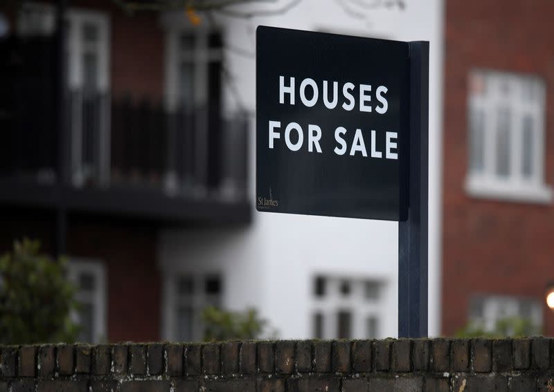 Property sale signs are seen outside of a group of newly built houses in west London