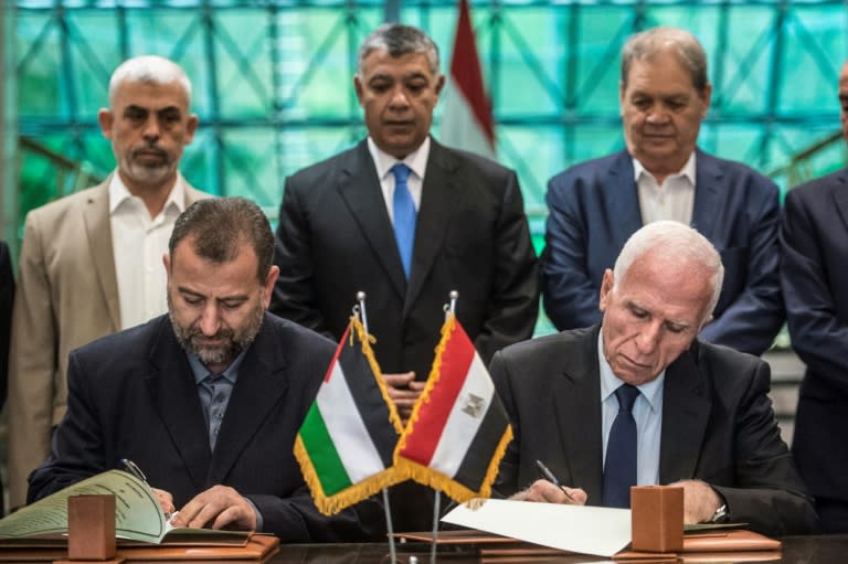 Saleh al-Aruri (L) of Hamas and Fatah's Azam al-Ahmad (R) sign a reconciliation deal at the Egyptian intelligence services headquarters in Cairo on October 12, 2017