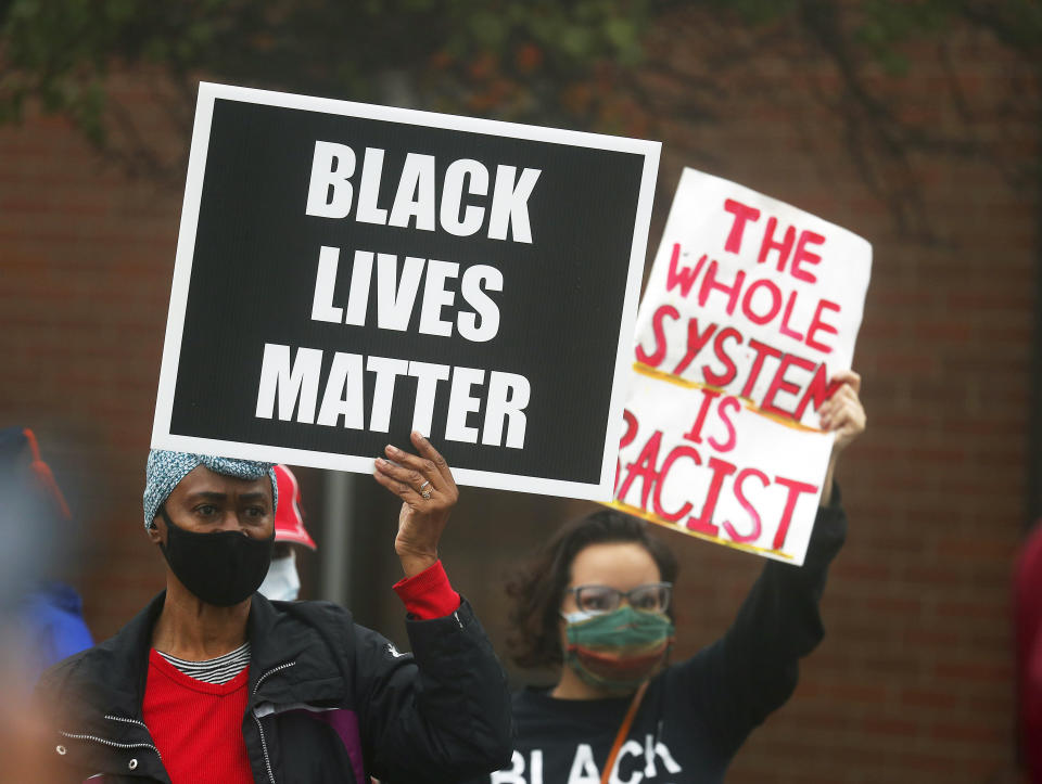 People hold signs during a protest rally for Marcellis Stinnette who was killed by Waukegan Police last Tuesday in Waukegan, Ill., Thursday, Oct. 22, 2020. Stinnette was killed and his girlfriend and mother of his child, Tafara Williams, was wounded when a police officer in Waukegan opened fire Tuesday night after police said Williams' vehicle started rolling toward the officer following a traffic stop. (Brian Hill/Daily Herald via AP)