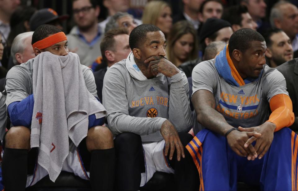 New York Knicks' Carmelo Anthony, left, J.R. Smith, center, and Amar'e Stoudemire, right, watch their team play during the first half of an NBA basketball game against the Philadelphia 76ers Monday, March 10, 2014, in New York. (AP Photo/Frank Franklin II)