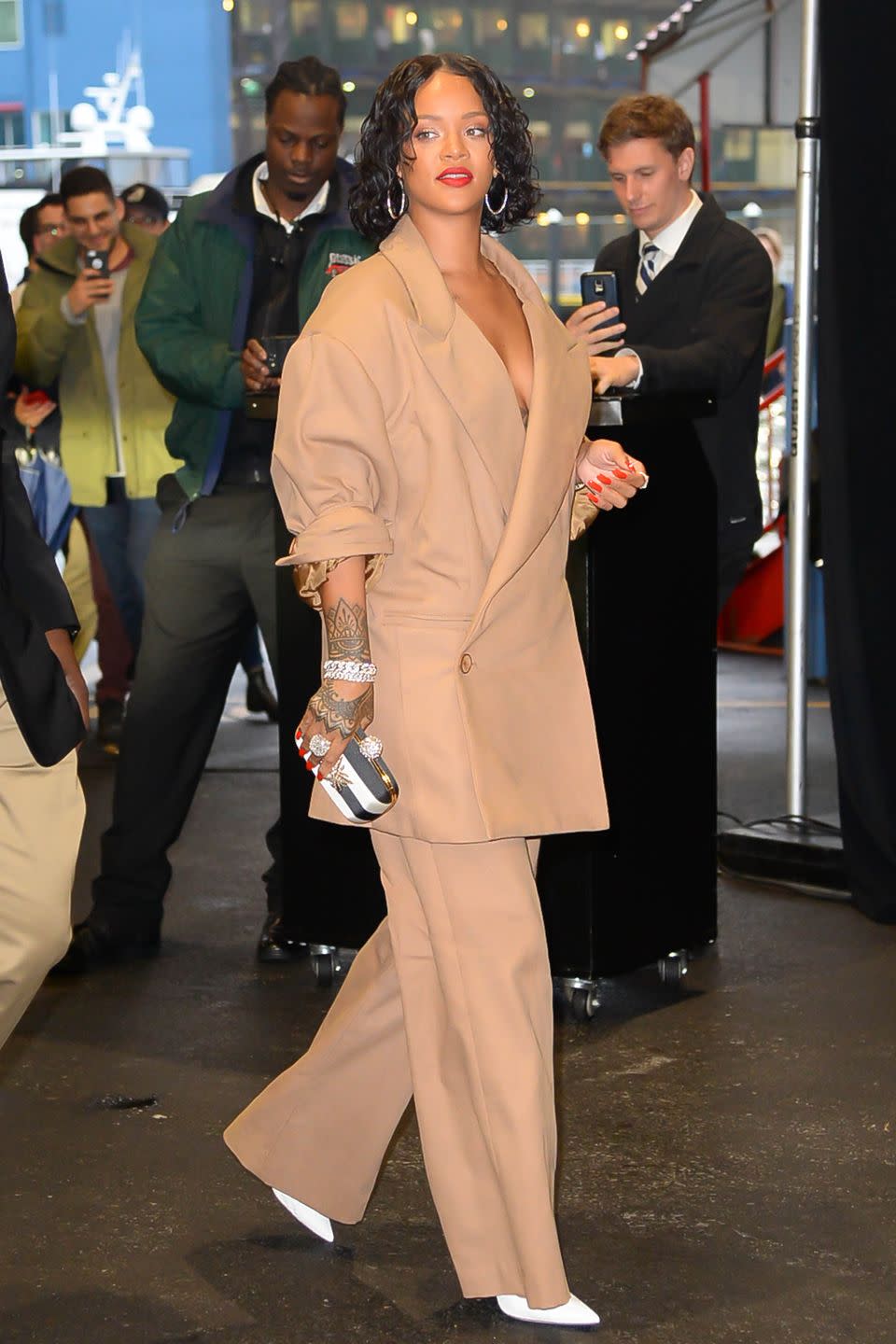 <p>In a custom Matthew Adams Dolan tan suit, striped clutch, white pumps and hoop earrings while out in New York City.</p>