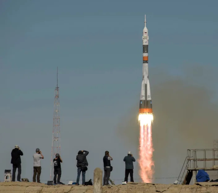 rocket launches past people watching and taking photos