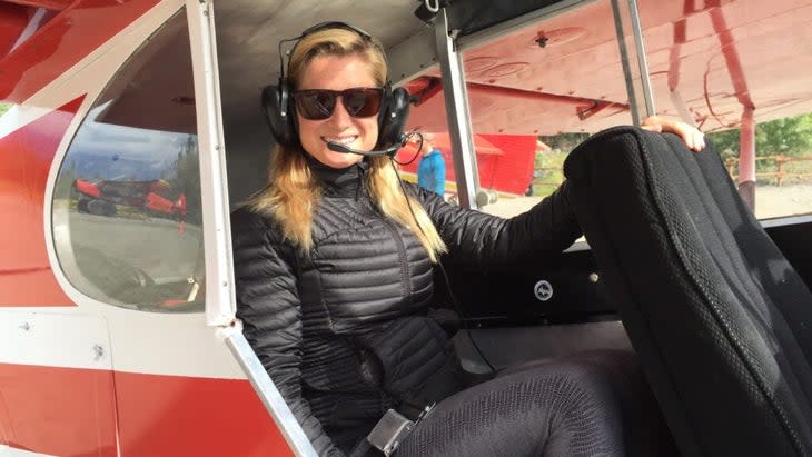 The author sitting inside a small plane, wearing earphones and attached mic