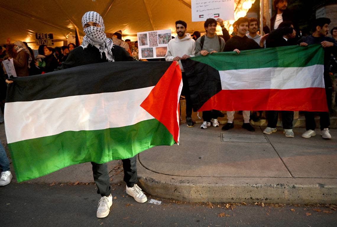 A Penn State student holds a Palestine flag as a group gathers in support at the Allen Street gates on Thursday, Oct. 12, 2023.