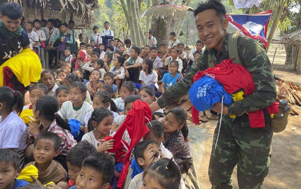 In this photo released by the Free Burma Rangers, members of the humanitarian group Free Burma Rangers distribute clothing to ethnic Karen children living in the jungles of remote northern Karen State to escape a local offensive by the Myanmar army, on Feb. 25, 2021. Aid organizations say more than 8,000 villagers have fled their homes after they came under mortar fire from the military. (Free Burma Rangers via AP)