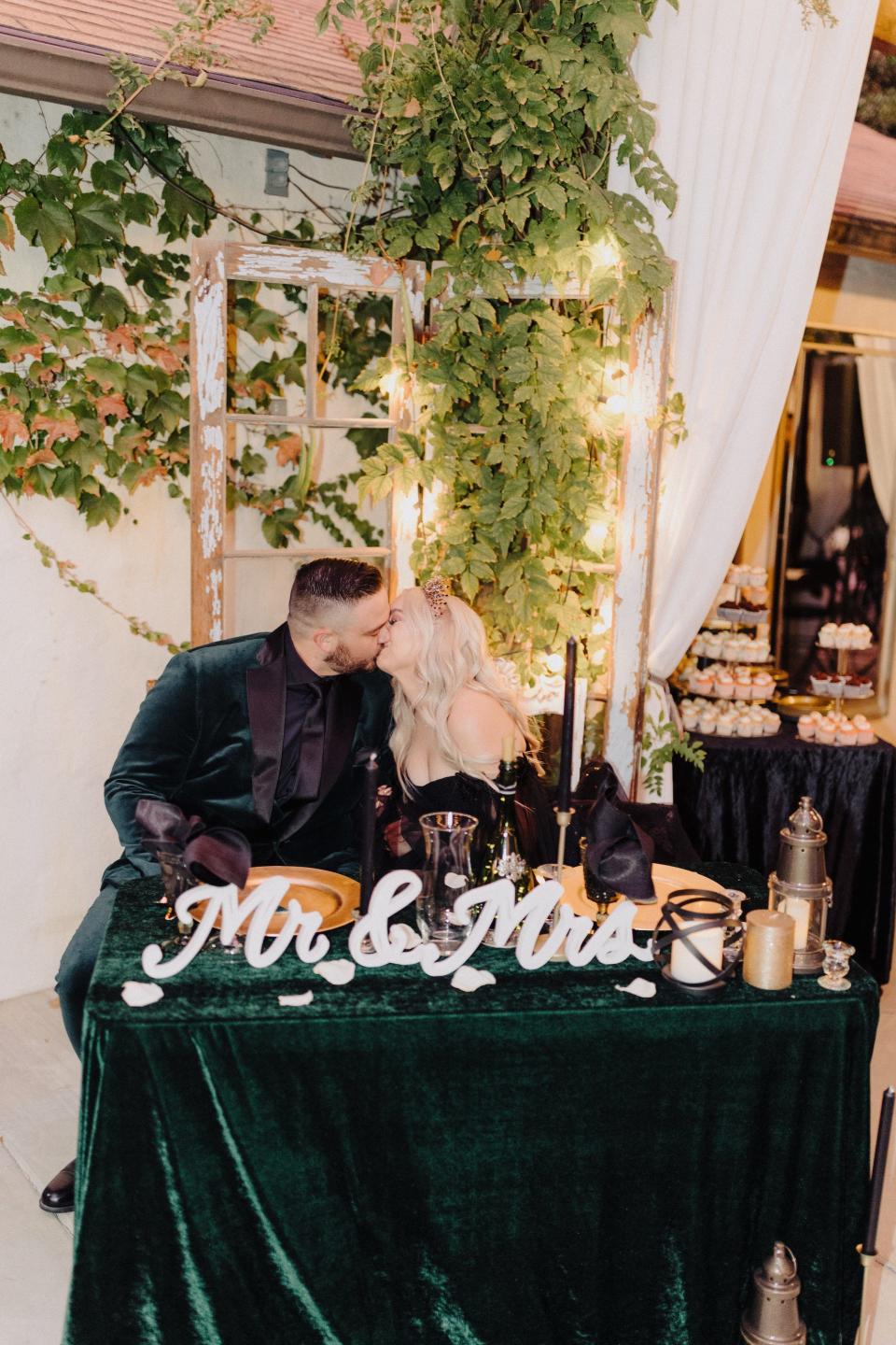 A bride and groom kiss at their sweetheart table.