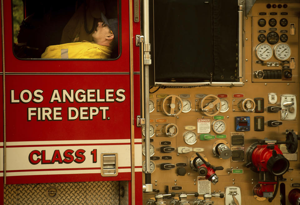 A firefighter rests as crews continue to battle the Saddleridge Fire burning in Porter Ranch, Calif., on Friday, Oct. 11, 2019. (AP Photo/Noah Berger)