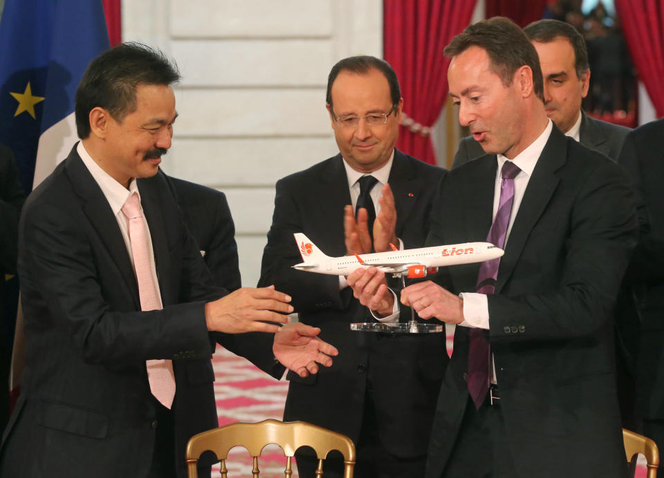 CEO of Airbus, French Fabrice Bregier, right, hands over an Airbus 320 model to CEO of Lion Air, Indonesian Rusdi Kirana, left, while France's President Francois Hollande stands behind during a signing ceremony at the Elysee Palace in Paris, Monday, March 18, 2013. Indonesian airline Lion Air is to buy 234 short to medium range aircraft from Airbus for 18.4 billion Euro($24 billion), in what is being billed as the biggest civilian deal in the history of the aircraft manufacturer. The contract was announced Monday at the French presidential palace, a sign of the deal's importance to the government. Airbus said it would secure 5,000 jobs at a time when French unemployment hovers around the 10 percent mark. (AP Photo/Michel Euler)