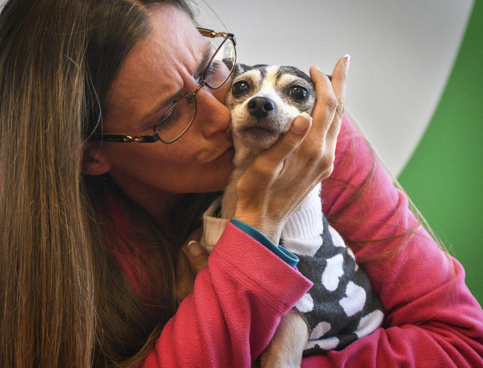 Katheryn Strang is reunited with her toy fox terrier "Dutchess" at Humane Animal Rescue on Friday, Oct. 11, 2019 in Pittsburgh. Humane Animal Rescue says the 14-year-old named Dutchess was found hungry, shivering and in serious need of a nail trim under a shed on Monday. The property owner took the dog to a Humane Animal Rescue location, where veterinarians were able to locate a microchip and trace the dog back to its owners in Boca Raton, Florida. (Steve Mellon/Pittsburgh Post-Gazette via AP)