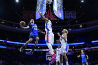 Orlando Magic's Cole Anthony (50) goes up for a shot against Philadelphia 76ers' Joel Embiid (21) during the first half of an NBA basketball game, Wednesday, Jan. 19, 2022, in Philadelphia. (AP Photo/Matt Slocum)