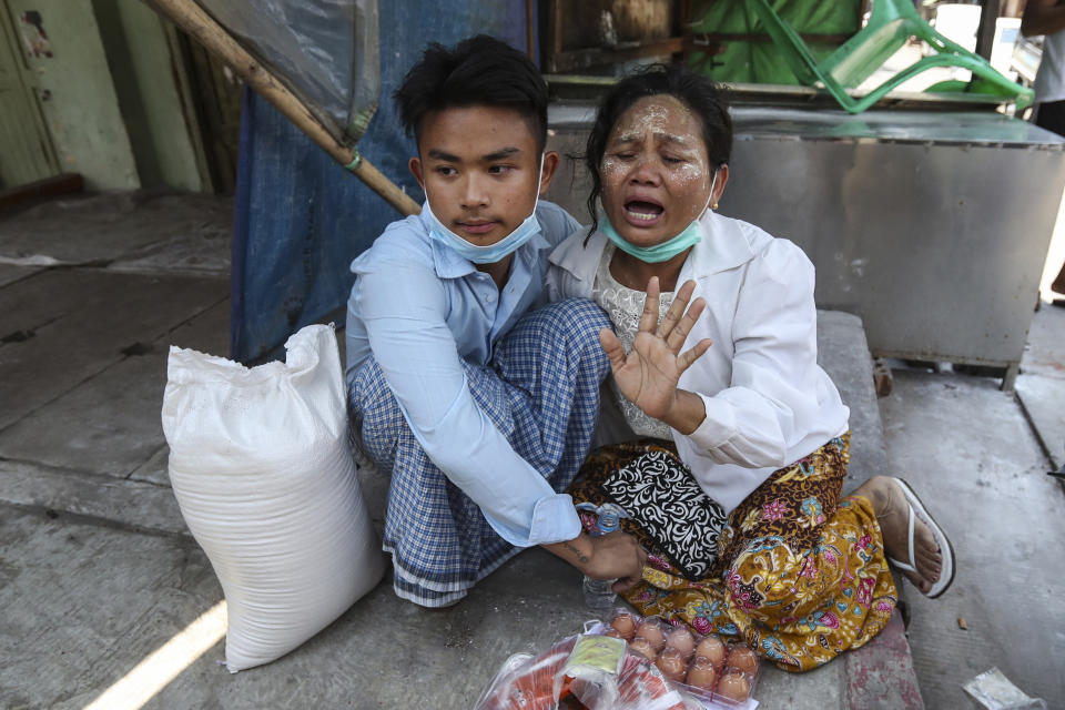 A mother cries after her son, left, was released from Insein prison by a presidential pardon in Yangon, Myanmar, Friday, April 17, 2020. Myanmar says it is releasing almost 25,000 prisoners under a presidential amnesty marking this week's traditional Lunar New Year celebration. (AP Photo/Thein Zaw)