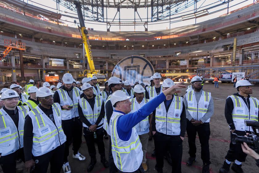 Los Angeles Clippers team members listen to Chairman Steve Ballmer, front center, at a ceremony celebrating the topping out of the Intuit Dome, future home of NBA basketball's Clippers, in Inglewood, Calif., Tuesday, March 7, 2023. (AP Photo/Damian Dovarganes)