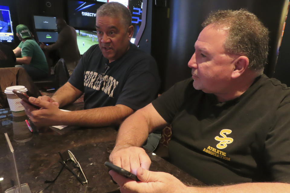 Anthony Sanguino, left and Jerry Veglia, right, discuss their bets at the Golden Nugget casino in Atlantic City N.J, while waiting for the March Madness college basketball tournament to begin in Atlantic City N.J. on Wednesday, March 21, 2024. The American Gaming Association estimates Americans will wager $2.72 billion with legal outlets this year. (AP Photo/Wayne Parry)