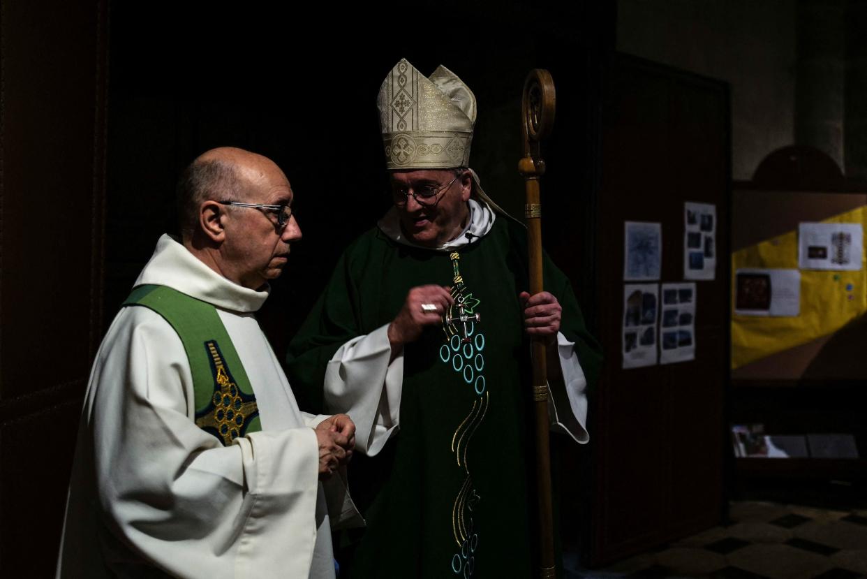 Father Didier Milani (L) speaks with Bishop Yves Le Saux (C) ahead of mass (AFP via Getty Images)