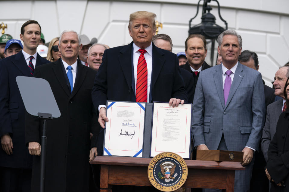 President Donald Trump shows off a new North American trade agreement with Canada and Mexico, during an event at the White House, Wednesday, Jan. 29, 2020, in Washington. The president is joined by, from left, senior advisers Jared Kushner and Ivanka Trump, Vice President Mike Pence, House Minority Whip Steve Scalise, R-La., U.S. Trade Representative Robert Lighthizer, House Minority Leader Kevin McCarthy of Calif., and others.(AP Photo/ Evan Vucci)