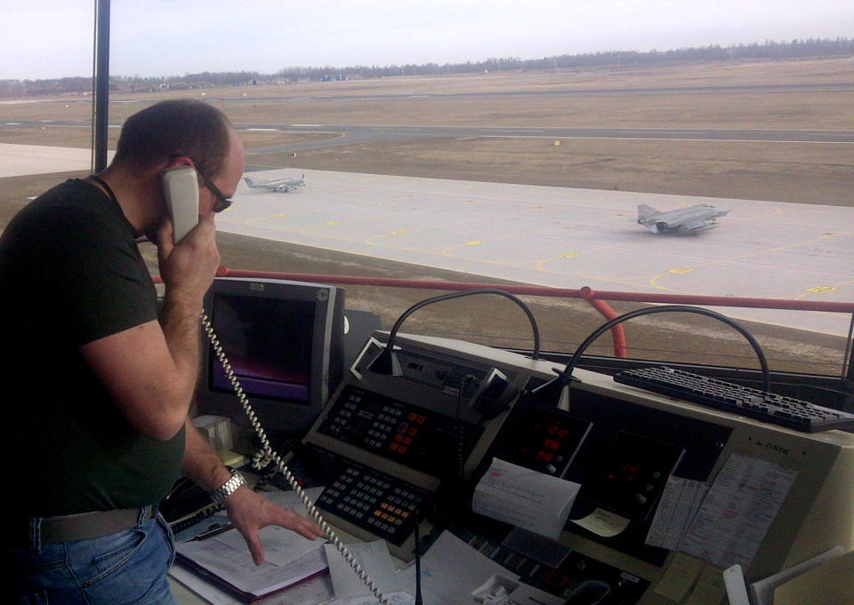 This Wednesday March 28, 2012 photo shows Vidas Baltrusaitis, a Lithuanian air traffic controller, directing air traffic at a former Soviet air base at Siauliai Air Base in Lithuania. He was on duty during an air policing exercise in which German F-4 fighter jets helped intercept an aircraft that had simulated losing communications as it neared Finnish airspace as part pf a NATO exercise. NATO hopes that international cooperation, with different member countries providing different capabilities, will save money in a time of austerity while building a full NATO-wide defense capability. (AP Photo/Don Melvin)