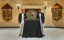 In this photo provided by Pakistan Cricket Board, Pakistan cricket team's skipper, Babar Azam, right, and his South Africa's counterpart Quinton de Kock pose for a photograph with the trophy of the test-series, in Karachi, Pakistan, Monday, Jan. 25, 2021. Pakistan and South Africa will play the first test match on Jan. 26. (AP Photo/Pakistan Cricket Board via AP)